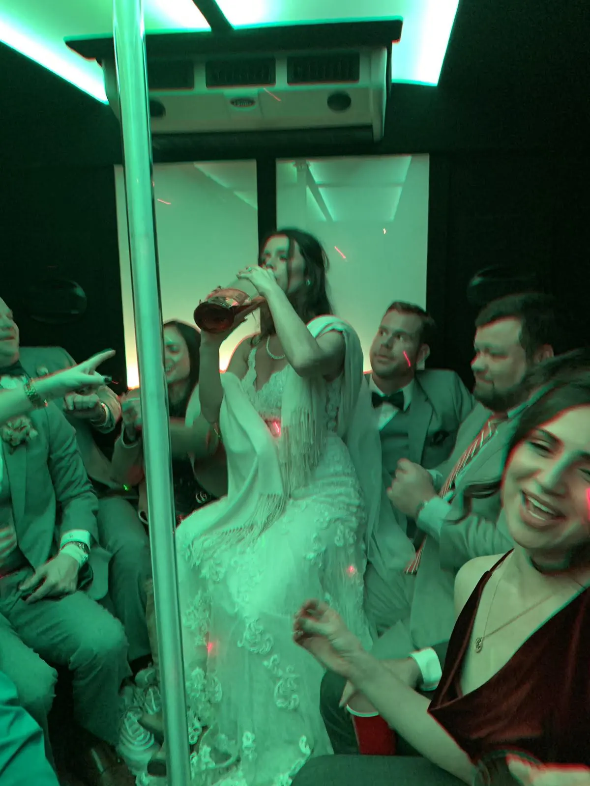 Group seated together in a green-lit vehicle cabin